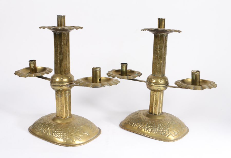 A pair of sheet-brass twin-branch candlesticks, circa 1905 Each with a square section pillar, and - Image 2 of 2