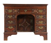 An oak knee-hole desk, English The top formed mainly from one large board, with ovolo-moulded