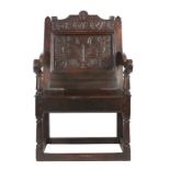 A Charles II oak panel-back open armchair, Lancashire, circa 1670 Having a flattened scroll profiled