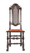 A William & Mary ebonized beech high back chair, circa 1690 Having an arched scroll-carved cresting,