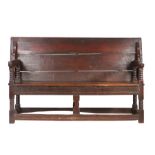 A Charles II oak table settle, circa 1680 Having a boarded and end-cleated back/top, on four ball-