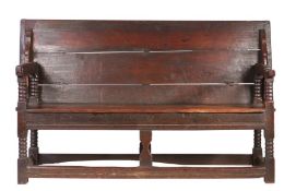 A Charles II oak table settle, circa 1680 Having a boarded and end-cleated back/top, on four ball-
