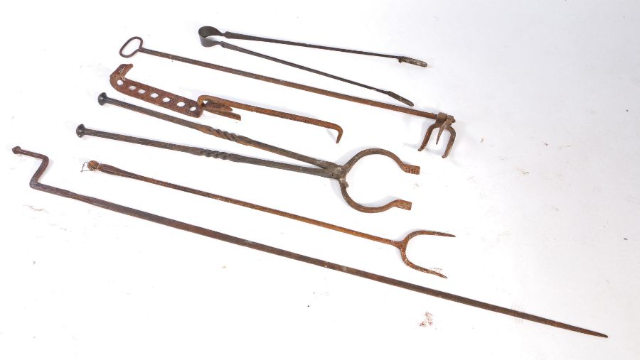 A group of iron fireside implements To include a log fork, tongs and adjustable hook (6) Provenance: - Image 2 of 2