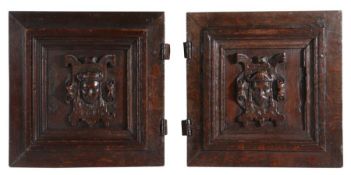 A pair of Elizabeth I carved oak boarded cupboard doors, circa 1570 Each carved with a figural