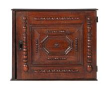 A Charles II oak table-top spice cupboard, circa 1680 Having a panelled and cushion mitre-moulded