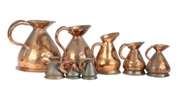 A group of eight 19th -early 20th century copper measures Of haystack form, half-gallon to half-gill
