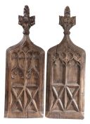 A pair of 15th century oak bench-ends, Each with a poppyhead finial. over carved quatrefoil,