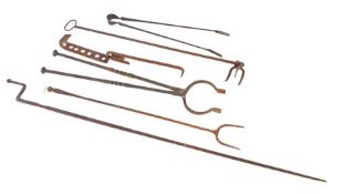 A group of iron fireside implements To include a log fork, tongs and adjustable hook (6) Provenance:
