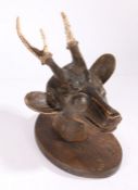 Folk art carved deer's head, the carved head with two carved antlers mounted on an oval shield,