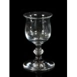A George III glass, with a flared lip above the bowl and a ring stem on wide arched foot with pontil