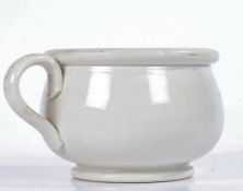 A Victorian pottery vomit pot, glazed in white with a loop handle and bulbous body, 13cm wide, 9cm