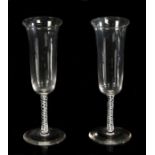 A pair of George III air twist champagne flutes, with flared lips above the white air twists on