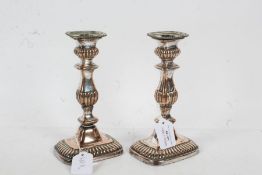 Pair of Victorian silver plated candlesticks, with a gadrooned and tapered body set on a gadrooned