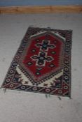 Turkish prayer rug, the red blue and cream ground set with multiple guls and a repeating border,
