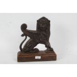 Cast iron door stop,in the form of a griffin, with wooden base, 26cm wide