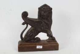 Cast iron door stop,in the form of a griffin, with wooden base, 26cm wide