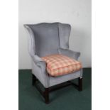 20th century mahogany and upholstered wing arm chair, upholstered in blue/grey fabric raised on