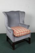 20th century mahogany and upholstered wing arm chair, upholstered in blue/grey fabric raised on