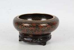 Japanese Cloisonne enameled bowl of shallow form, decorated with brick red flowers on a brown