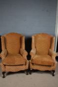 Pair of George III style wing back armchairs,the chairs upholstered in a orange fabric with a