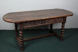 20th century oak refectory dining table, with a rounded plank top above scroll carved frieze and