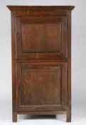 An early 18th century oak upright cupboard, French With two cut-corner and fielded panelled doors,