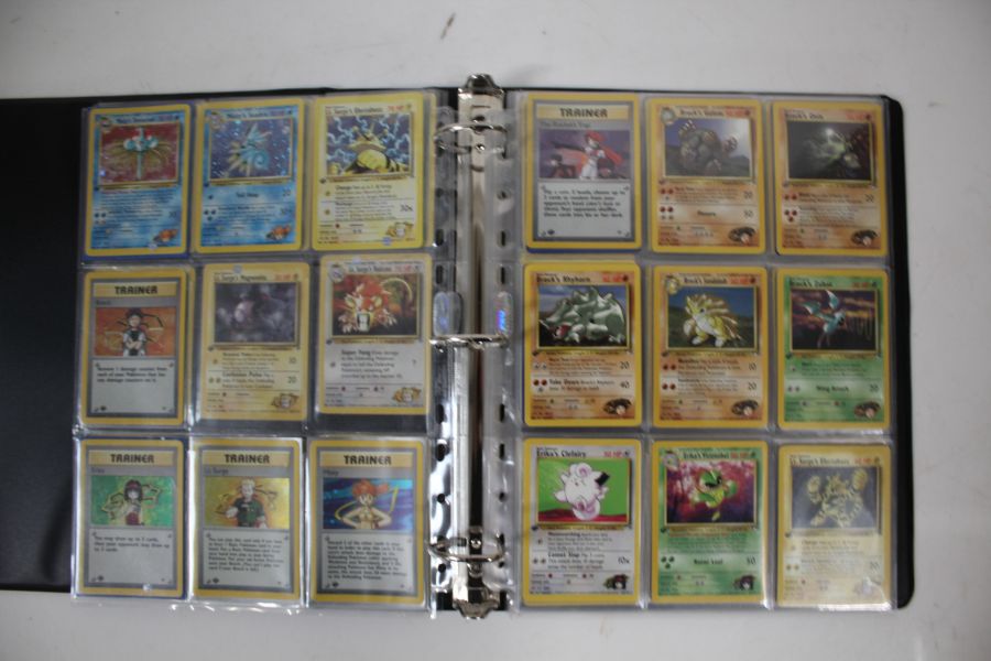 A collection of 1st Edition Gym Heroes Pokémon cards housed in a folder. To include a full non