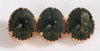 A 9 carat gold and  three scarab beetle brooch, with three beetles to the shaped bar, 36mm wide, 2.