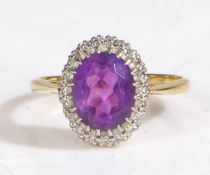 18 carat gold diamond and amethyst ring, the head set with a oval faceted stone surrounded by