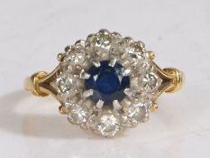 An 18 carat gold sapphire and diamond set ring, with a central sapphire and a diamond surround, ring