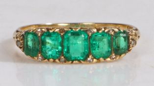 An 18 carat gold and emerald set ring, with a row of five emeralds, ring size O1/2, 3.4g