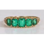 An 18 carat gold and emerald set ring, with a row of five emeralds, ring size O1/2, 3.4g