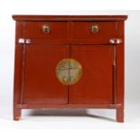 19th century Chinese red lacquered side cupboard, the plank top above two small drawers and pair