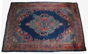 Large Middle Eastern wool carpet, with red floral border and centred with a diamond shaped medallion