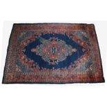 Large Middle Eastern wool carpet, with red floral border and centred with a diamond shaped medallion