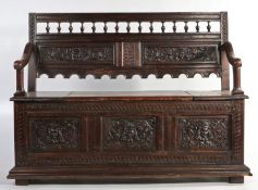 Victorian oak hall seat, the spindle turned top rail above two mask, foliate and scroll carved