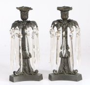 Pair of Regency bronzed candlesticks with prismatic glass lustre drops, the scroll cast sconces