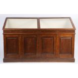 Oak museum display cabinet, the sloping hinged glazed top above four cupboard doors, raised on a