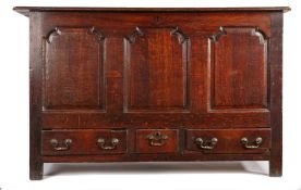 A 18th Century oak mule chest, the rectangular hinged top above three fielded arched panels and