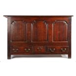 A 18th Century oak mule chest, the rectangular hinged top above three fielded arched panels and