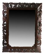 Large ornate carved oak mirror, having scrolling pierced frame and bevelled mirror, 112cm high, 88cm