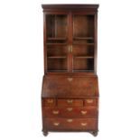 A George III oak and glazed bureau bookcase With two glazed cupboard doors enclosing two