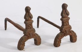 Pair of cast iron fire dogs, the terminals modelled as a figure praying, 33cm high, 41cm deep