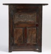 A part 17th Century oak cupboard, the rectangular top above a panelled door with carved lozenge