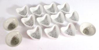 Eleven white porcelain strainer dishes, in the form of hearts, three similar circular strainer