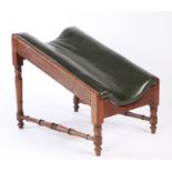 Victorian mahogany gout stool, the dished sloping green leather upholstered support raised on turned