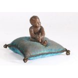 A 19th century French pin cushion, the turquoise cushion surmounted by a terracotta depiction of a