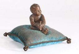 A 19th century French pin cushion, the turquoise cushion surmounted by a terracotta depiction of a