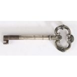 Early 19th Century silver sheathed key, the shell and scroll pierced terminal above a reeded stem