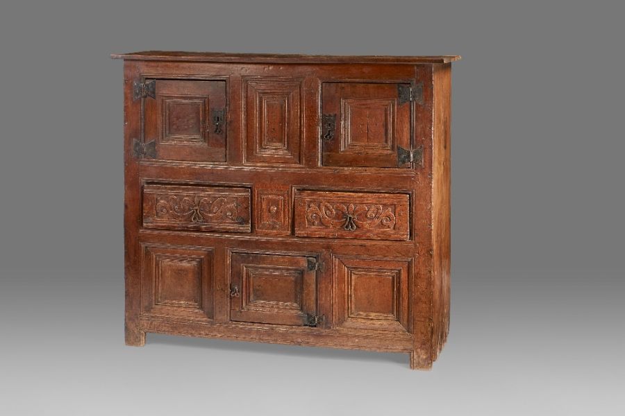 A rare Henry VIII oak joined and boarded livery cupboard, circa 1520-40 The top of two boards with